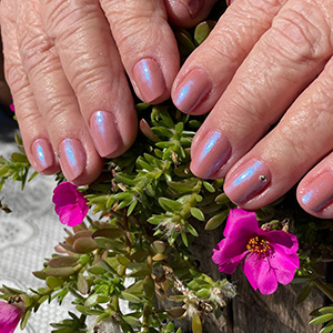 Manicure rosa em cenário florido