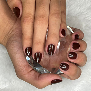 Manicure vinho decorada com linhas brancas