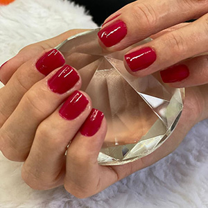 Manicure vermelha fotografada em detalhe