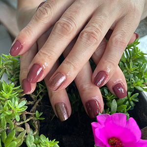 Manicure rosada em cenário florido